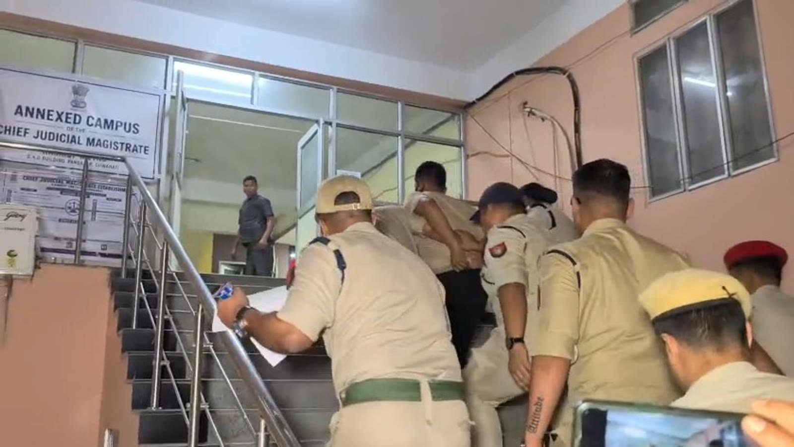 Police escort Ghanakanta Gogoi from Paltan Bazar station to court